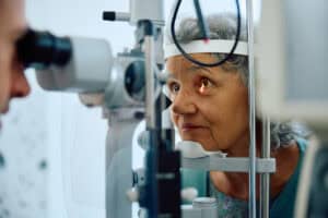 Senior woman receiving an eye exam for cataract evaluation.