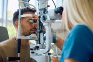 Man receiving an eye exam for conjunctivitis symptoms.