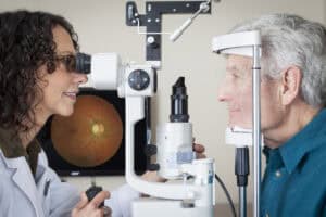 Optometrist examining a patient’s eyes for macular degeneration.