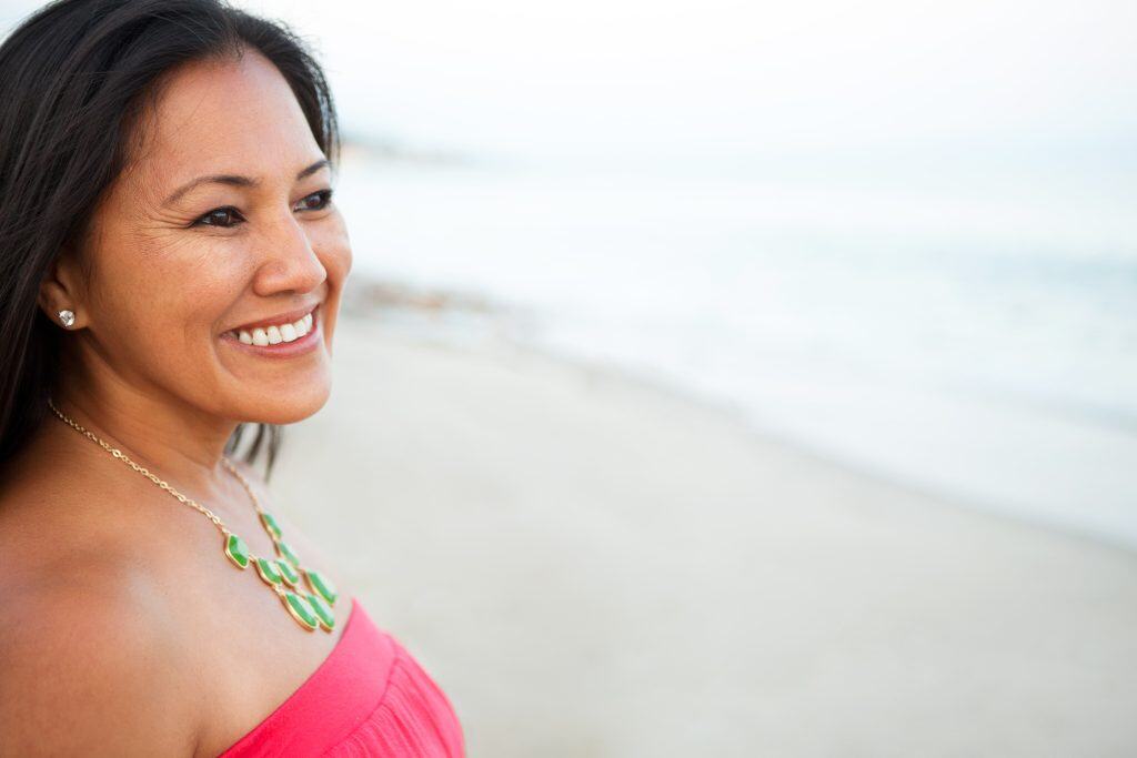 Beautiful confident woman looks out on the beach without glasses on